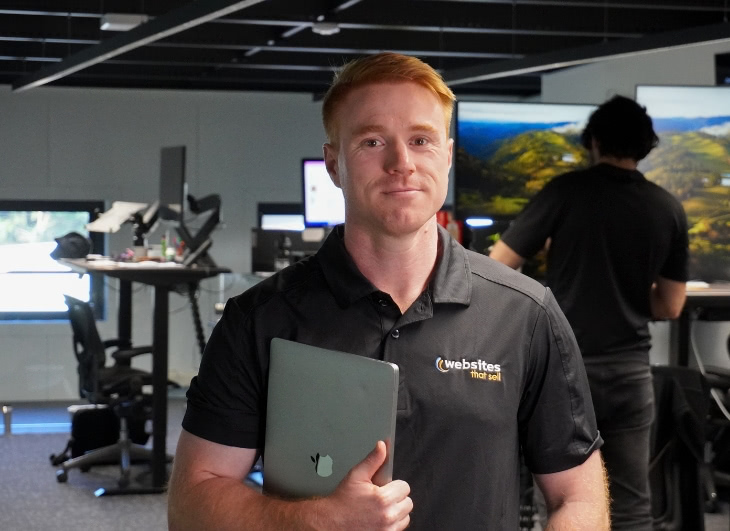 Patrick out Paid Ads specialist holding his work laptop.